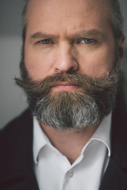 Close up portrait of a worried businessman on gray background - Fotoğraf, Görsel