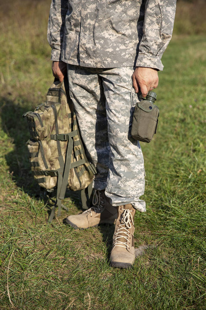 The soldier holds a flask - Foto, imagen