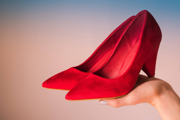 Woman holding red high heels on hand - Photo, Image