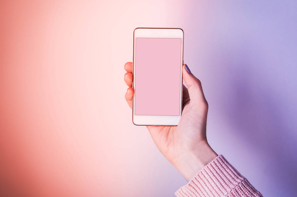 Рука с экраном мобильного телефона на розовый и фиолетовый
 - Фото, изображение