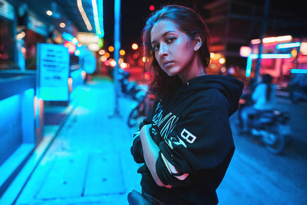 Neon close up portrait of young woman wear hoodie. night city street shot - 写真・画像