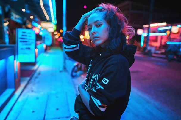Neon close up portrait of young woman wear hoodie. night city street shot - Zdjęcie, obraz
