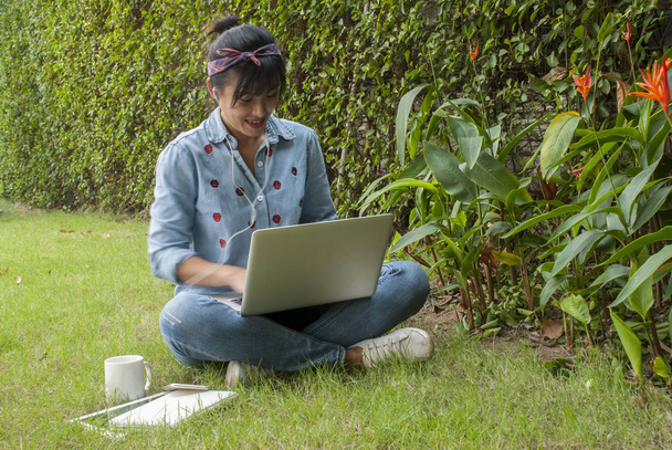 Naiset käyttävät kannettavia tietokoneita puutarhassa
. - Valokuva, kuva