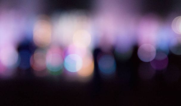 Stadtbrunnen mit farbiger Beleuchtung in der Nacht unscharf.  - Foto, Bild