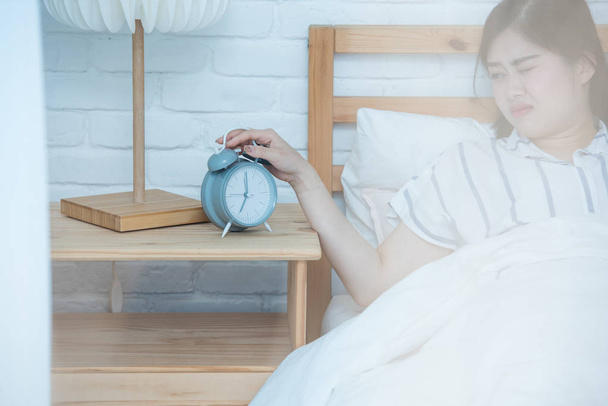 Despertar de un dormido Asiático Chicas parar despertador en la cama
 - Foto, imagen
