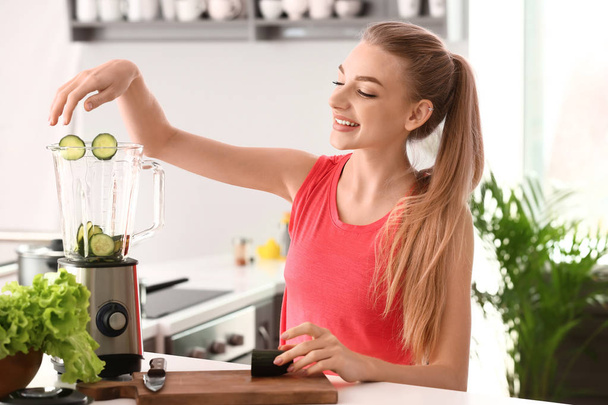 Jovem mulher fazendo smoothie saudável em casa
 - Foto, Imagem