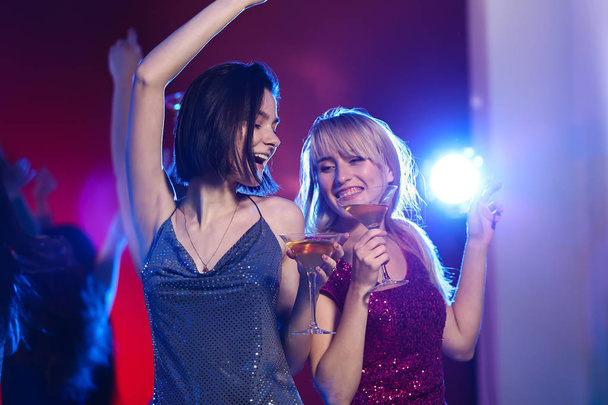 Belle giovani donne con cocktail alla festa nel night club
 - Foto, immagini