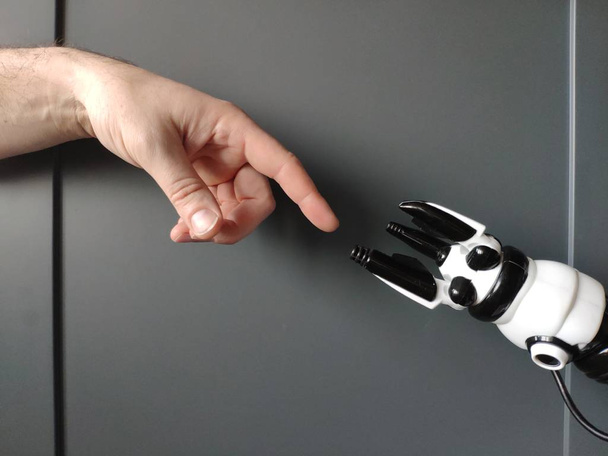 La main d'un homme tend le bras vers un robot, ressemble à une fresque de Michel-Ange
. - Photo, image