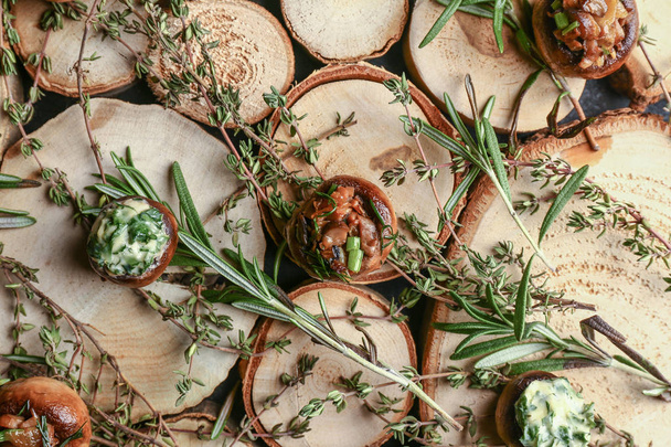 Smaczne grzyby faszerowane ziołami na drewnianym stole - Zdjęcie, obraz