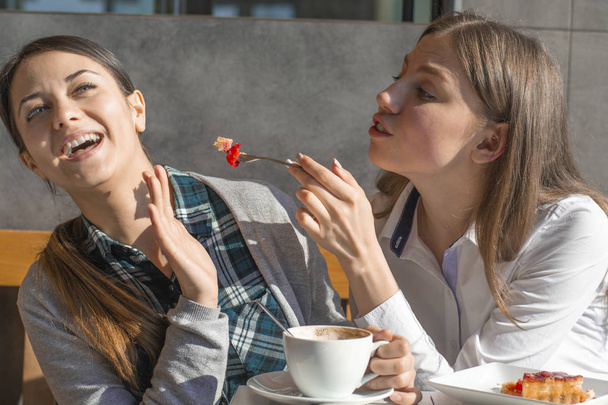 dvě dívky přátelé v pití kávy café, smát se, jedna dívka odmítá sladký - Fotografie, Obrázek