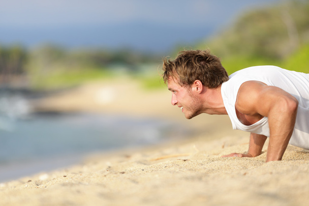 Push-ups - man fitness model training on beach - Foto, Imagen