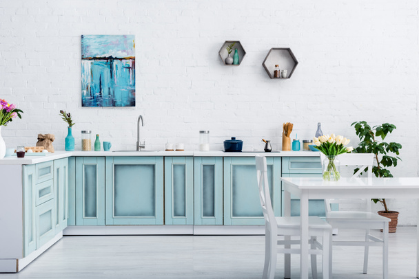interior of turquoise and white kitchen with kitchenware and decor  - Фото, изображение