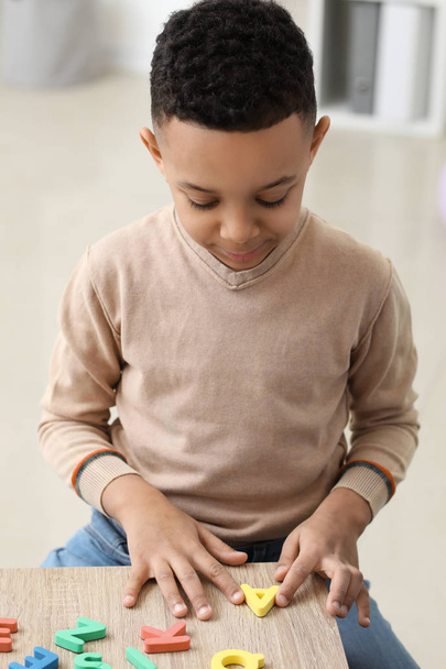 Petit garçon composant des mots de lettres au bureau de l'orthophoniste
 - Photo, image