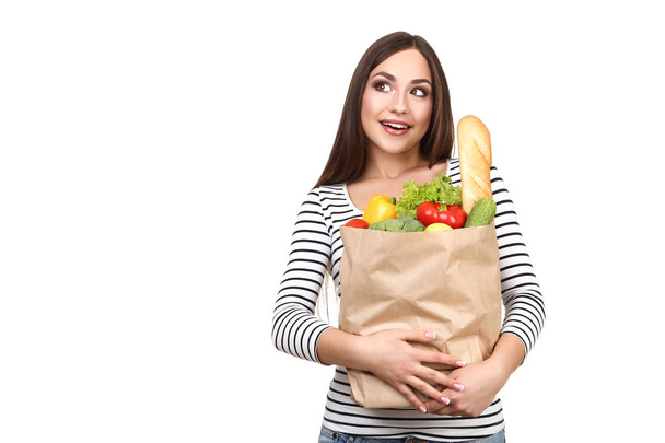 Beautiful woman holding grocery shopping bag on white background - 写真・画像