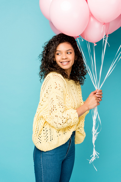 beautiful african american girl holding pink air balloons isolated on blue - Фото, зображення