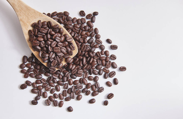 grains de café avec cuillère en bois et fermer sur fond blanc et isolé
.  - Photo, image