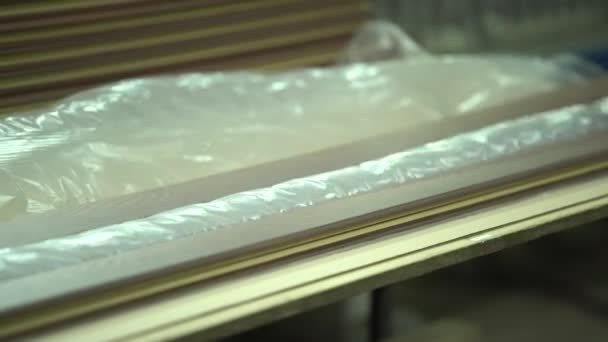 Shooting of packing of plinths. Ready plinths pack into a transparent film. in a shot the worker's hands are visible. Production of plinths. Close-up shot. Plinths are packed on several pieces. Work manually. - Footage, Video