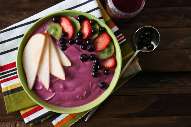 Bowl with tasty acai smoothie on wooden table - Photo, Image