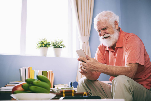 Homme barbu âgé pleurant en lisant le message texte
 - Photo, image