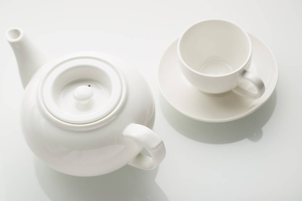 White teapot and white cap on the white background  - Fotó, kép