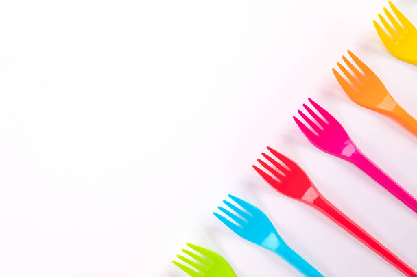Many color plastic forks on a bright background - Foto, imagen