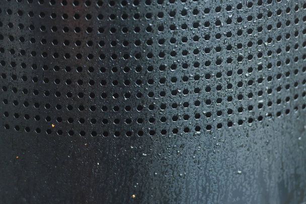 Perforált fém. Sok lyuk a vas-lemez. Fekete perforált textúra. Fekete pontok szürke háttérrel - Fotó, kép