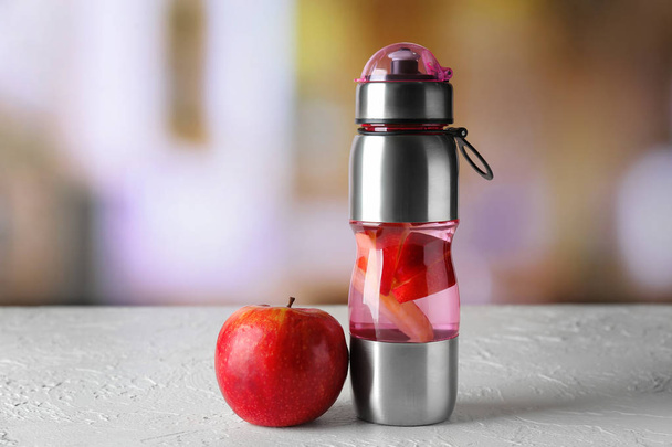 Bottle of infused water and apple on table - Fotó, kép
