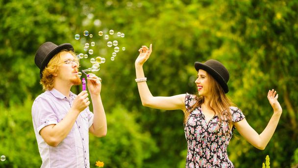 Couple blowing bubbles outdoor - Foto, afbeelding