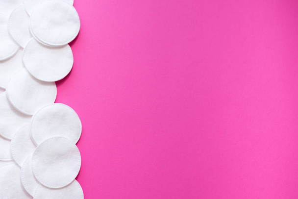 cotton pads on pink background, top view.disk for beauty face hygiene . Beauty, skin, body care concept.selective focus. place for text. frame - 写真・画像