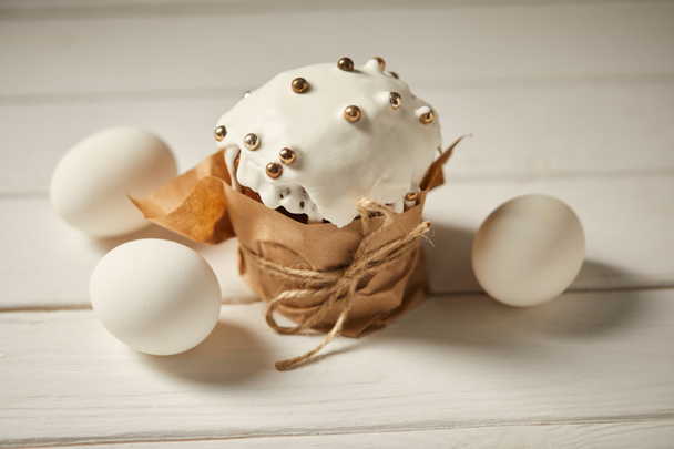 вкусный традиционный пасхальный торт с куриными яйцами на белой деревянной поверхности
 - Фото, изображение