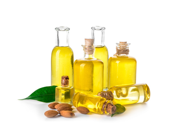 Bottles of almond oil on white background - Фото, изображение