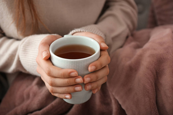 Mladá žena pít horký čaj doma, closeup - Fotografie, Obrázek