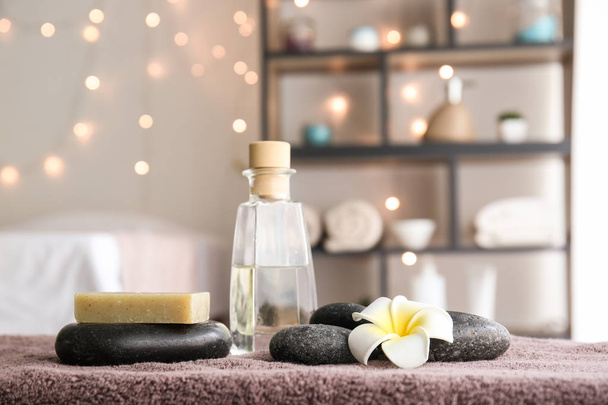 Masážní kameny a kosmetické výrobky na stole ve spa salonu - Fotografie, Obrázek