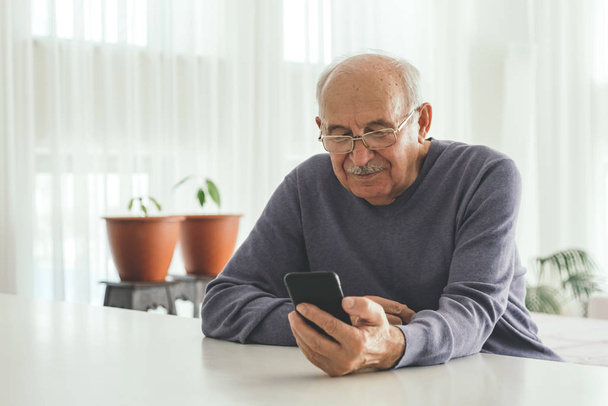 Retired man using computer technologies at home.  - Foto, Imagem