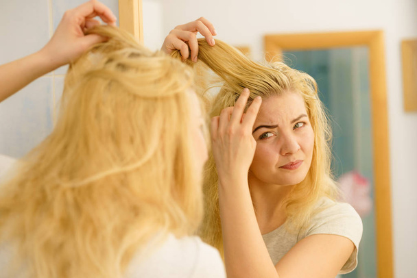Female having problem with blonde hair - Valokuva, kuva