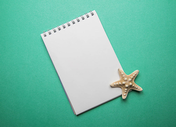 white blank notepad on green background - Фото, изображение
