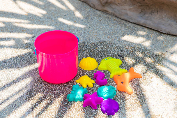 childrens beach bright pink toys on a sandy concrete background. - Photo, Image
