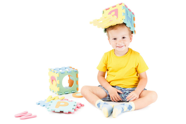 Boldog gyermek óvodai tanulás olvasni, játszani a színes ABC. - Fotó, kép