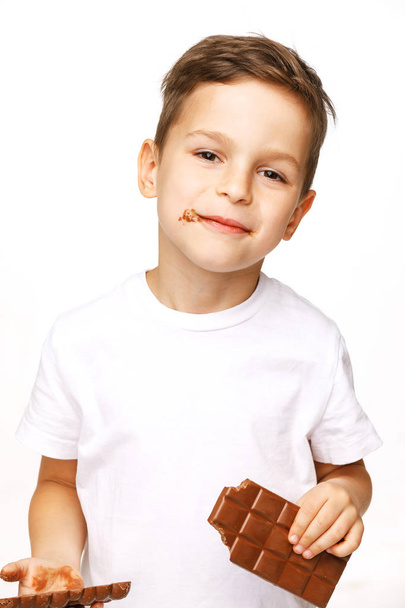 little beautiful boy eating chocolate studio shot  - Zdjęcie, obraz