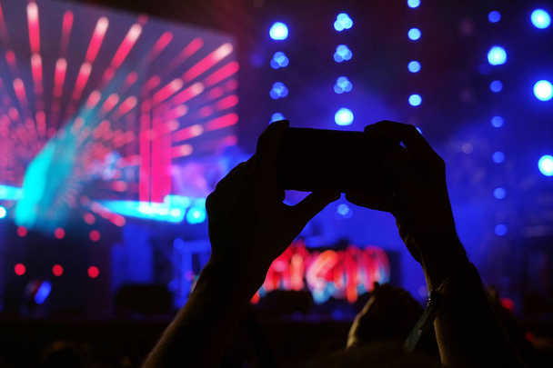 Mains tenant smartphone sur le concert du festival
. - Photo, image