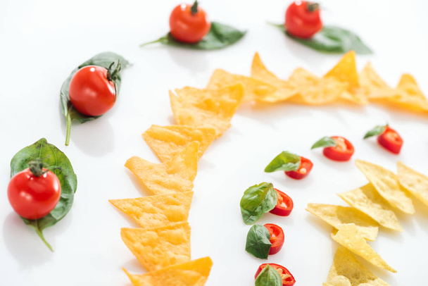 selektywny nacisk na smaczne nachos, pomidory wiśniowe i papryka chili z bazylii  - Zdjęcie, obraz