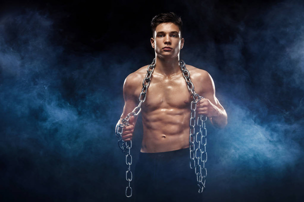 Teenager men sportsmen. Portrait of a brutal boy with chains. Athlete bodybuilder on black background. - Valokuva, kuva
