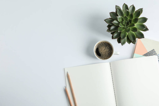 Копировальные книги, чашка кофе, карандаш и сочное растение на белом фоне
 - Фото, изображение