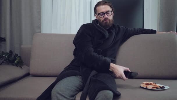 Handsome bearded man relaxing on sofa - Кадри, відео