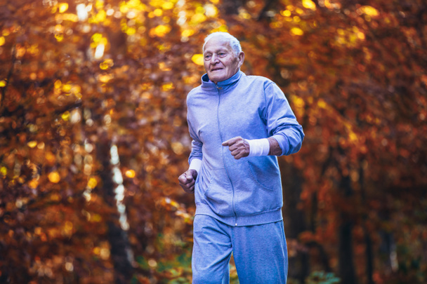 Старший бегун по природе. Пожилой спортсмен бегает в лесу дю
 - Фото, изображение
