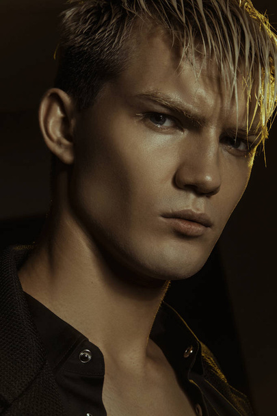 Handsome stripped blonde male model wearing black suit on black isolated font background - Φωτογραφία, εικόνα