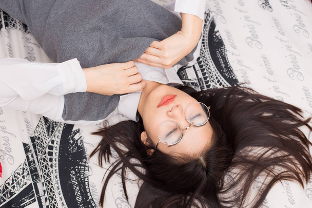 Gafas de mujer relajarse acostado en la cama
 - Foto, Imagen