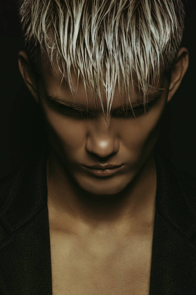 Handsome stripped blonde male model wearing black suit on black isolated font background - Fotografie, Obrázek