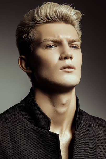 Handsome stripped blonde male model wearing black suit  on gray isolated font background - Fotografie, Obrázek