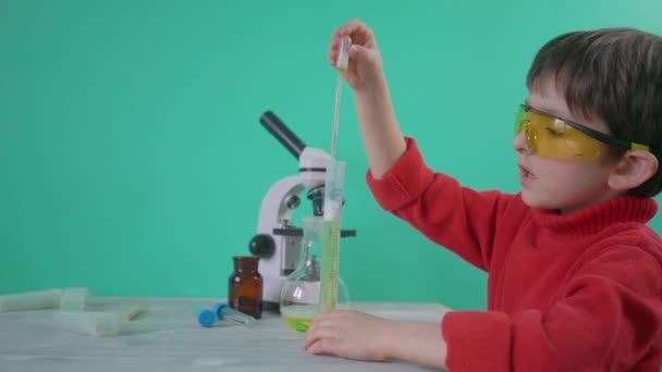 A little boy pouring liquid into a tube - Video